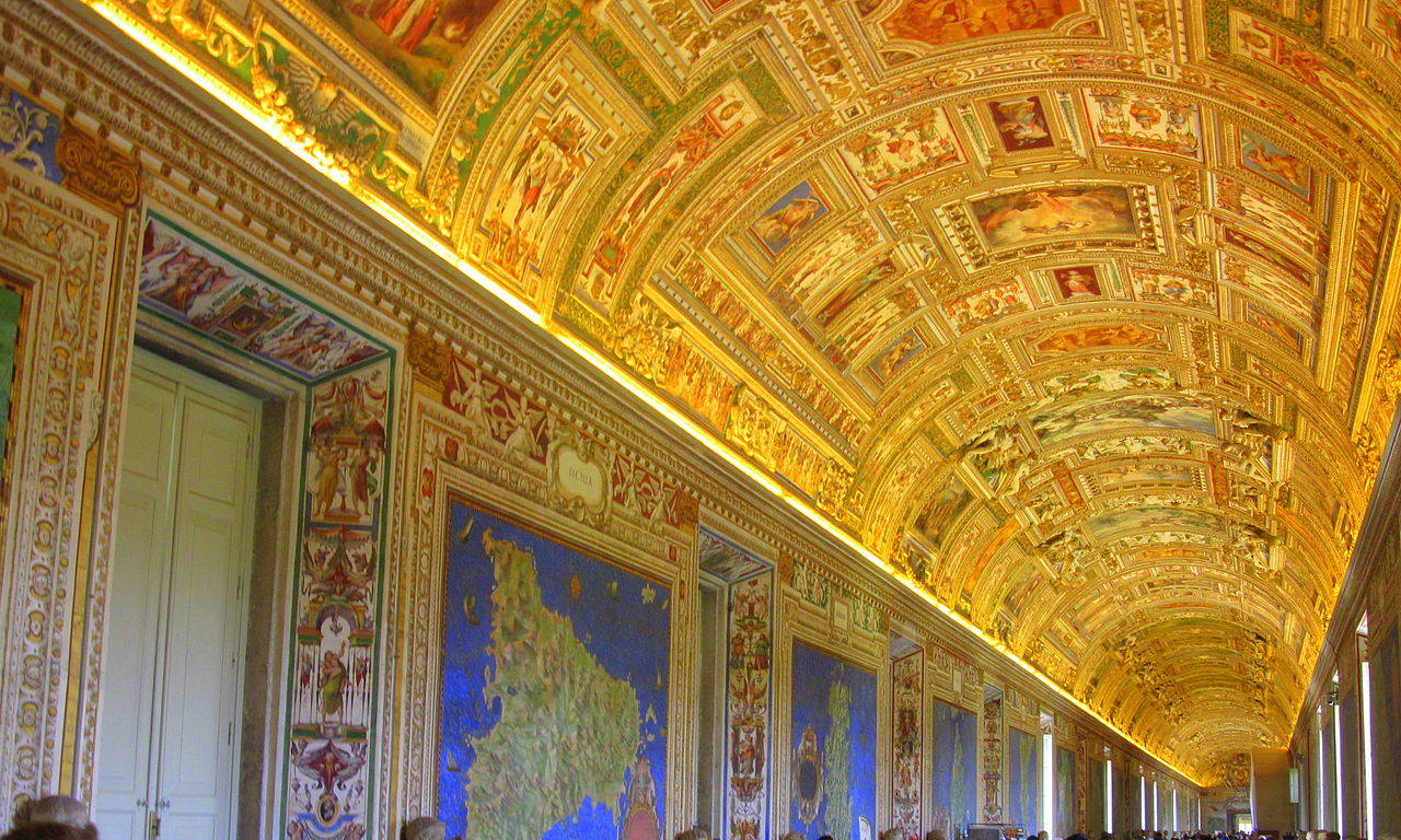 An arched hallway ceiling with paintings and golden frames